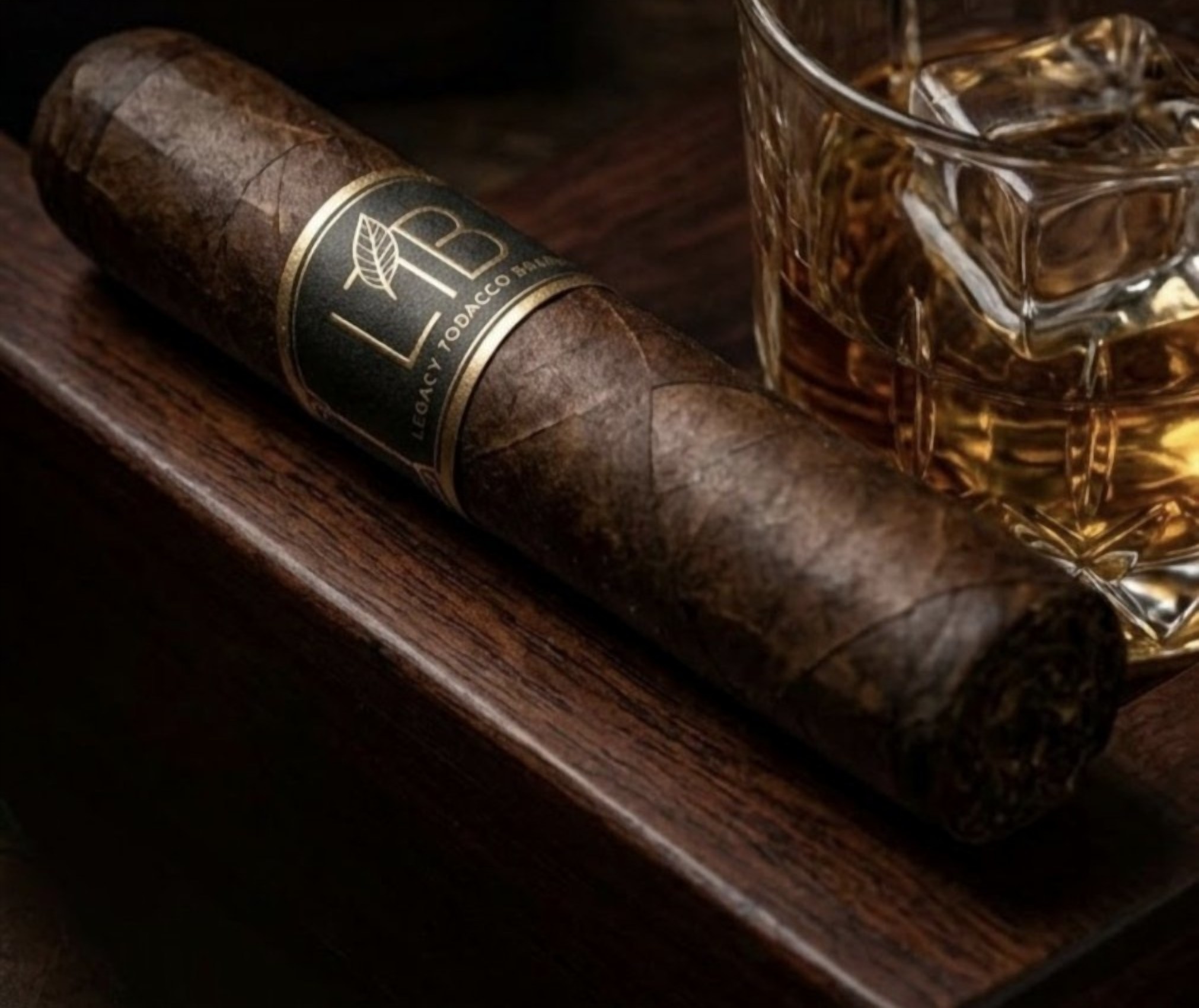 Legacy Tobacco Brands cigar with band beside a whiskey glass